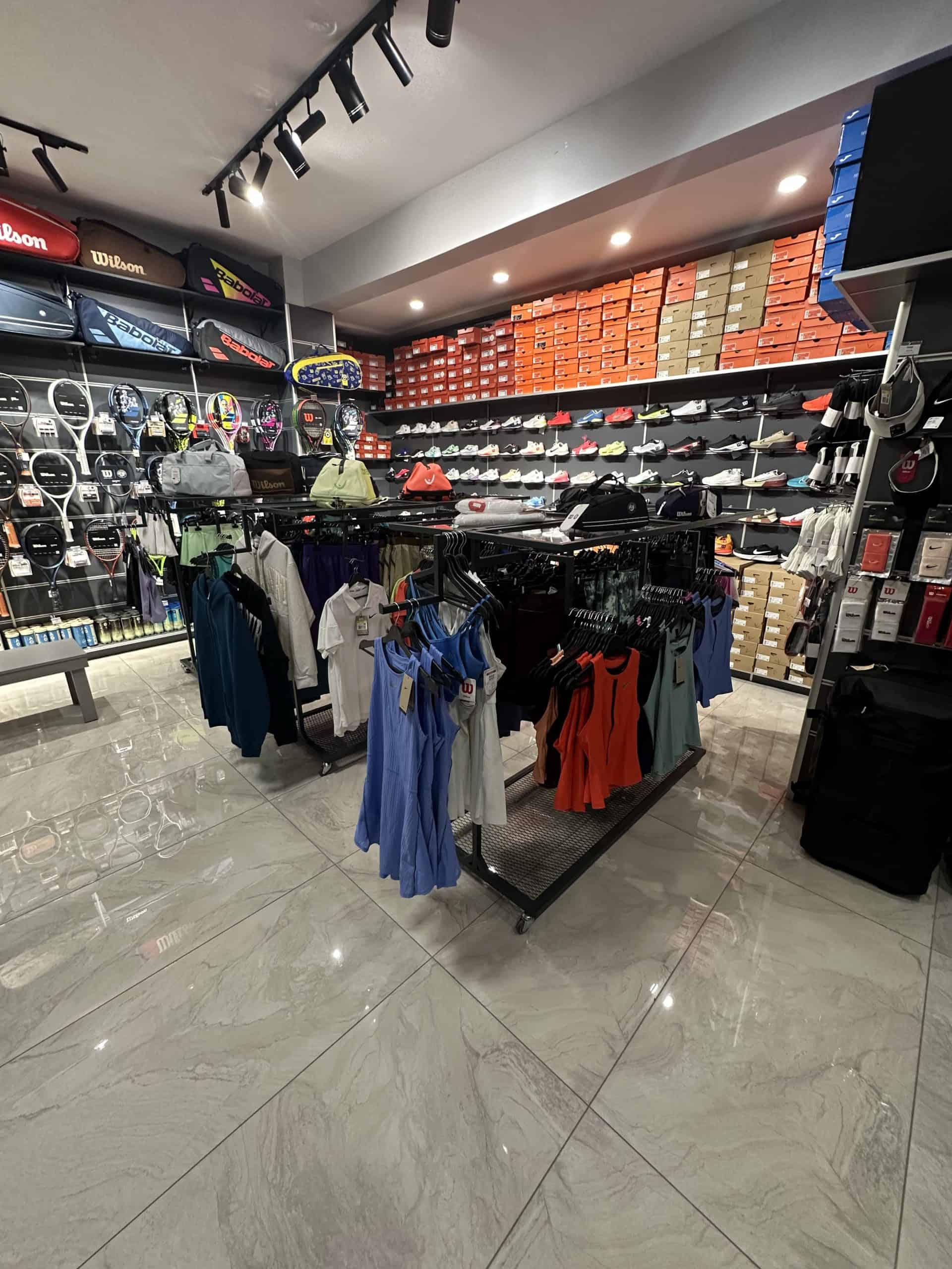 Nike ve Wilson tenis kıyafetleri ile arkada Nike ve Wilson tenis ayakkabıları – Renda Tenis İzmit Kocaeli mağaza görüntüsü