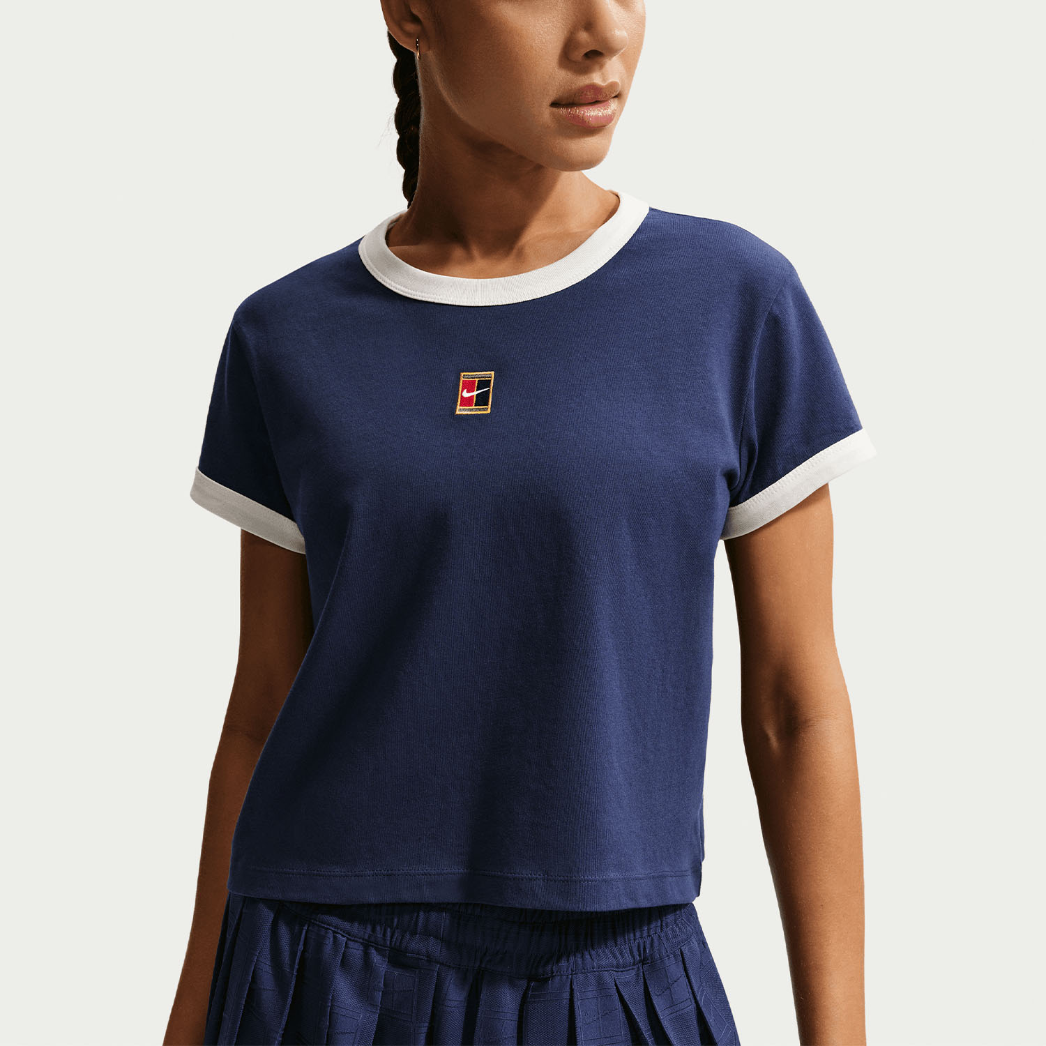 Nike Heritage kadın tenis tişörtünü keşfedin. Midnight Navy Sail renkli, %100 pamuklu, regular fit, hafif cropped ve tenis ilhamlı detaylara sahip model IH5059-410 şimdi Renda Tenis’te.